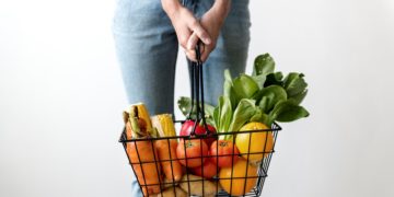 woman holding basket vegetables